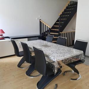 una mesa y sillas en una habitación con escalera en Appartement Malawo, en La Flèche