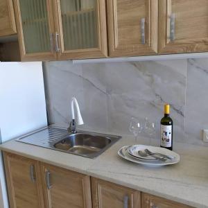 a kitchen counter with a sink and a bottle of wine at Studio Aphrodite in Afiartis