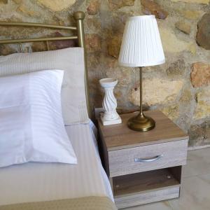 een lamp op een nachtkastje naast een bed bij Studio Aphrodite in Afiartis