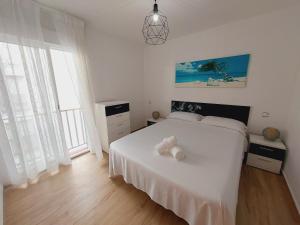 a bedroom with a white bed and a large window at CalafellBeach.SeaViews,New in Calafell