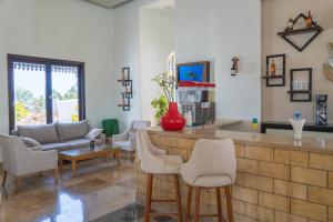 Sharm Club Beach Resort في شرم الشيخ: غرفة معيشة مع بار مع كراسي وأريكة