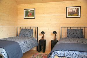 um quarto com duas camas e duas fotografias na parede em Dzikie Lisko - Domek Południowy em Lesko