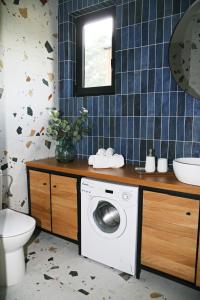 uma casa de banho com uma máquina de lavar roupa e um lavatório em Dzikie Lisko - Domek Południowy em Lesko