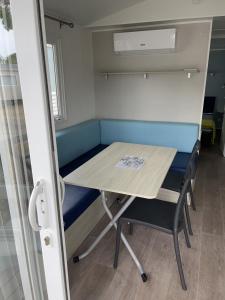 un tavolo e sedie in una piccola stanza di Mobile home camping a Le Grau-du-Roi