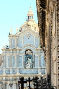 um grande edifício com uma estátua em frente em Duomo Housing Catania Le Suites em Catânia