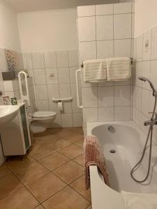 y baño con bañera, aseo y lavamanos. en Naturzauber, en Üdersdorf