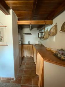 a kitchen with wooden cabinets and a tile floor at La Casita in Fuente del Oro