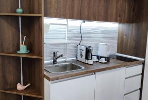a kitchen counter with a sink and a microwave at Apartman Modiano in Vrnjačka Banja