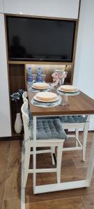 una mesa de comedor con platos y platos. en Apartman Modiano en Vrnjačka Banja