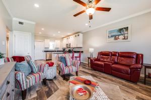 uma sala de estar com um sofá de couro vermelho e cadeiras em Tinas Island Retreat IR42 em Port Aransas