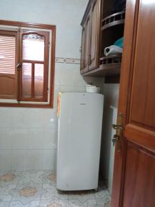 einen kleinen weißen Kühlschrank in einer Küche neben einer Tür in der Unterkunft Appart centre in Larache