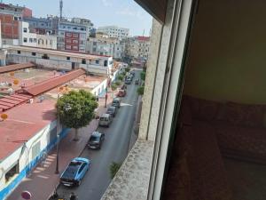 una vista da una finestra di una strada cittadina con auto di Appart centre a Larache