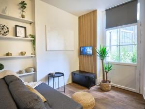 a living room with a couch and a window at Très élégant duplex, proche Gare in Grenoble