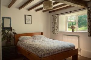 1 dormitorio con cama y ventana en Whichford Mill-large Cotswold Home, en Shipston on Stour