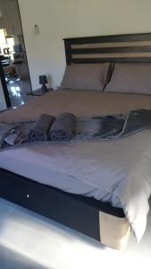 Una cama con dos almohadas encima. en Wanderlust Hostel, en Bergville