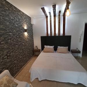 een slaapkamer met een bed en een bakstenen muur bij Studio near the port !!! in Paralia Katerinis