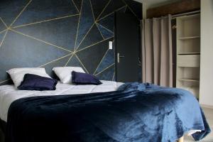 sypialnia z dużym łóżkiem z fioletowymi poduszkami w obiekcie Domaine des Marronniers w mieście Tourtrol