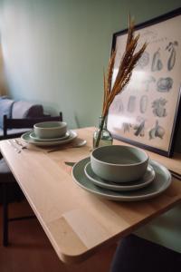 una mesa de madera con dos platos y un jarrón en ella en London Buck, en Stralsund