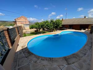 una gran piscina azul en un patio en Casa Juani, en Ateca