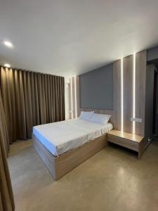 a bedroom with a large bed with a white bedspread at Castra villas - Pool Villa in Parunthumpara in Vandiperiyār