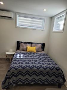 um quarto com uma cama com uma almofada amarela em Studio sous-sol Lachine 10 min de DT em Montréal