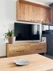 un centro de entretenimiento de madera con TV de pantalla plana en Sparrow apartmens 3, en Košice