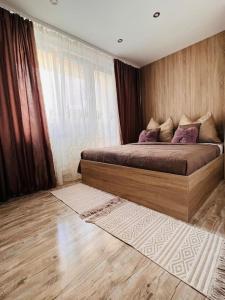 1 dormitorio con 1 cama grande con almohadas moradas en Sparrow apartmens 3, en Košice