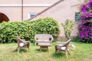 three chairs sitting in the grass in a yard at B&B Mirella & Patrick in Boccea +9 photos
