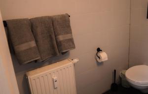 a bathroom with towels and a toilet and a radiator at London Buck in Stralsund