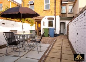 un tavolo e sedie con ombrellone su un patio di Modern Luxury house in Farnborough a Farnborough