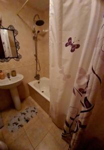 ein Bad mit einem Duschvorhang und einem Waschbecken in der Unterkunft EL APARTAMENTO DE AMY CON VISTAS AL MAR in Mazagón