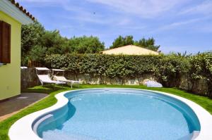 a swimming pool in the backyard of a house at Villa Nadia in Tanaunella