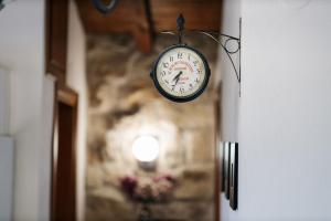 a clock hanging from a wall in a hallway at The Serenity Stone Lodge in Kavala