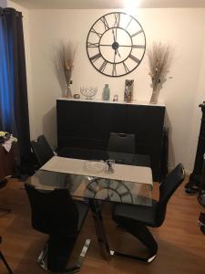 a dining room with a table and a large clock at Appartement 60 m², porte de Saint-Cloud in Boulogne-Billancourt