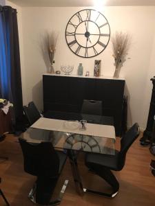 a dining room with a table and a large clock at Appartement 60 m², porte de Saint-Cloud in Boulogne-Billancourt +10 photos