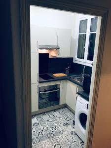 una pequeña cocina con fregadero y lavavajillas en Appartement 60 m², porte de Saint-Cloud, en Boulogne-Billancourt