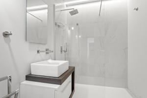 a white bathroom with a sink and a shower at Cascais Terrace in Cascais +23 photos