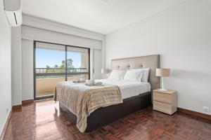 een slaapkamer met een groot bed en een groot raam bij Cascais Terrace in Cascais