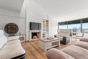 Cascais Terrace في كاسكايس: غرفة معيشة بأثاث أبيض وموقد