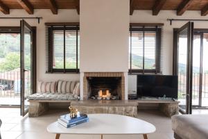 a living room with a fireplace and a television at The Serenity Stone Lodge in Kavala