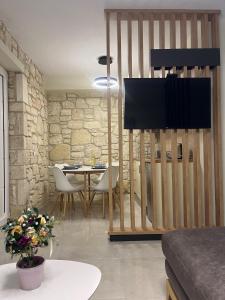un soggiorno con un tavolo e una televisione di Sun & Stone House a Polykhrono