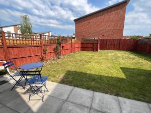 a patio with a table and chairs and a fence at 3 Bed Stylish house with parking close the Etihad in Manchester