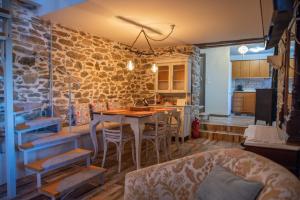 a kitchen with a table and chairs and a stone wall at Zoes House in Makrirrákhi