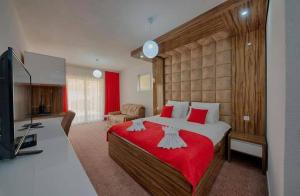 a bedroom with a large bed with a red blanket at Hotel &Scaron;ARS in Dobra Voda