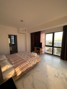 a bedroom with a bed and a large window at ELIZ Luxury Residence in Mamaia