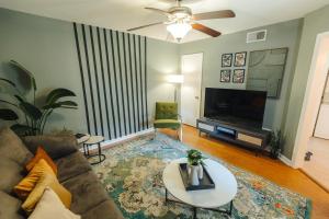 uma sala de estar com um sofá e uma televisão em Centrally Located 2BR Overton Square Unit 1 Fast WiFi Free Parking Yes Pets em Memphis