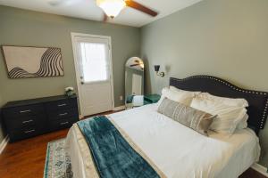 um quarto com uma cama com lençóis brancos e uma janela em Centrally Located 2BR Overton Square Unit 1 Fast WiFi Free Parking Yes Pets em Memphis