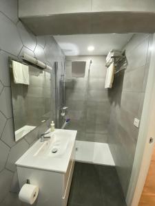 a white bathroom with a sink and a shower at El Refugio de Maman in Bilbao