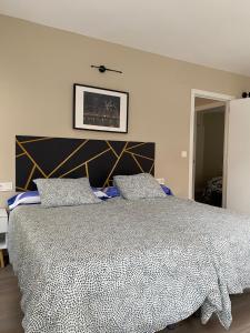 a bedroom with a bed with a black and white comforter at El Refugio de Maman in Bilbao