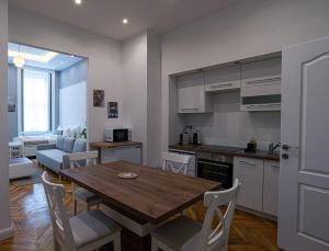 een keuken en eetkamer met een houten tafel en stoelen bij Joy Apartments on Kiraly street in Boedapest